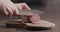 man slicing salami on olive wood board