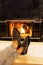 Man in slippers relaxing with his feet up with a fireplace in the background.