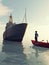 Man in a small boat looking at a ship .