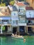 Man in small boat by waterside houses