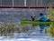 Man in small paddle boat fishes in the wetlands at Cachuma Lake, Santa Barbara County