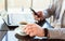 Man in smart watch drinking coffee on work space. Man using laptop, holding smart phone for business work or study. Close up smart