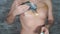 Man smearing cream on incomplete tattoo on his chest. Close-up of men`s hand applying ointment to part of body.