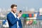 Man smile in formal suit with mobile phone outdoor. Happy businessman with smartphone on sunny terrace. Business communication and