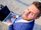 Man smiling cheerful face work with laptop close up. Businessman formal suit looks back while holds open screen laptop