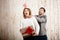 Man smothering girl holding christmas gift over wooden background.