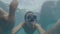 Man snorkeler in mask and tube swimming among wild whale shark in clear sea water and shooting selfie video. Man