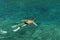 Man snorkeling with flippers, mask and snorke in lazure, clear seawater of Adriatic Sea. Flecks of sunlight in the seawater. Top v