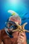 Man in snorkeling gear with mask and snorkel is showing a starfish