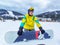 man with snowboard sitting at snowed hill