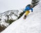 Man snowboarder in goggles freeride-descending using carving technique. Off-piste touring in snowy mountains. Copy space