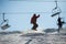 Man snowboarder jumping at ski resort against ski-lift