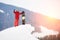 Man snowboarder standing on the top of the snowy slope with snowboard, showing thumbs up at winter ski resort