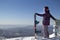 A man in snowboarding gear on the top of a mountain. Young man standing with a snowboard on the top of the mountains