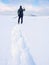 Man with snowshoes and backpack take photos by smartphone. Hiker in snowdrift