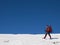 A man in snowshoes walks in the mountains with a backpack.