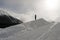 A man on the snowy hill watching the snowy landscape and mountains in the alps switzerland