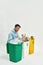 Man sort garbage in glass, plastic and paper bins