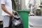 man sorting plastic bottles in garbage disposal point in front of a house in the city before a garbage truck comes to collect its