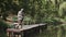 Man in special uniform fishing on a wooden pier in a park