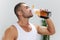 Man sports drinking water during break from workout, pumped up man fitness trainer works out at home, the concept of