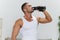 Man sports drinking water during break from workout, pumped up man fitness trainer works out at home, the concept of