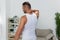 Man sports neck pain, workout injury at home, pumped up man fitness trainer works out at home, health and body beauty