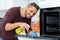 Man spraying cloth in oven