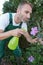 man spraying flowers in garden pest control gloved hand