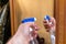 Man sprays mirror cleaner, hand close-up