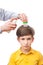 Man is sprinkling child head by anti-nits spray