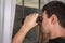 Man is spying his neighbours with binoculars