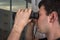 Man is spying his neighbours with binoculars