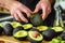 man squeezing avocados for ripeness