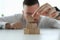 A man stacks wooden blocks on a table close-up