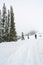 A man stand facing the mountain on a path cover with snow