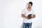Man standing against white wall holding football