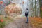 A man standing in a autum landscape in front of giant human brain. The brain is currently transmitting information and operations