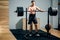 Man standing by a barbell safety stand in a gym