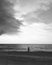 Man standing on beach against storm cloud