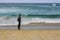 Man standing on a beach and looking at the ocean