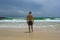 Man standing at the beach and watching the ocean