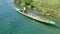 Man standing in the bow rowing the wooden boat