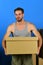 Man standing among cardboard boxes and holding one