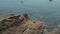 Man is standing on a cliff above a clear blue sea