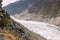 A man standing on the cliff looking at the Passu glacier.