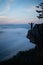 Man standing on the edge of the rock hanging above the scenery valley