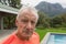 Man standing with exercise mat near poolside in the backyard