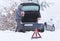 Man standing in front of damaged car holding bottle of antifreeze coolantin.