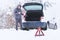 Man standing in front of damaged car holding bottle of antifreeze coolantin.